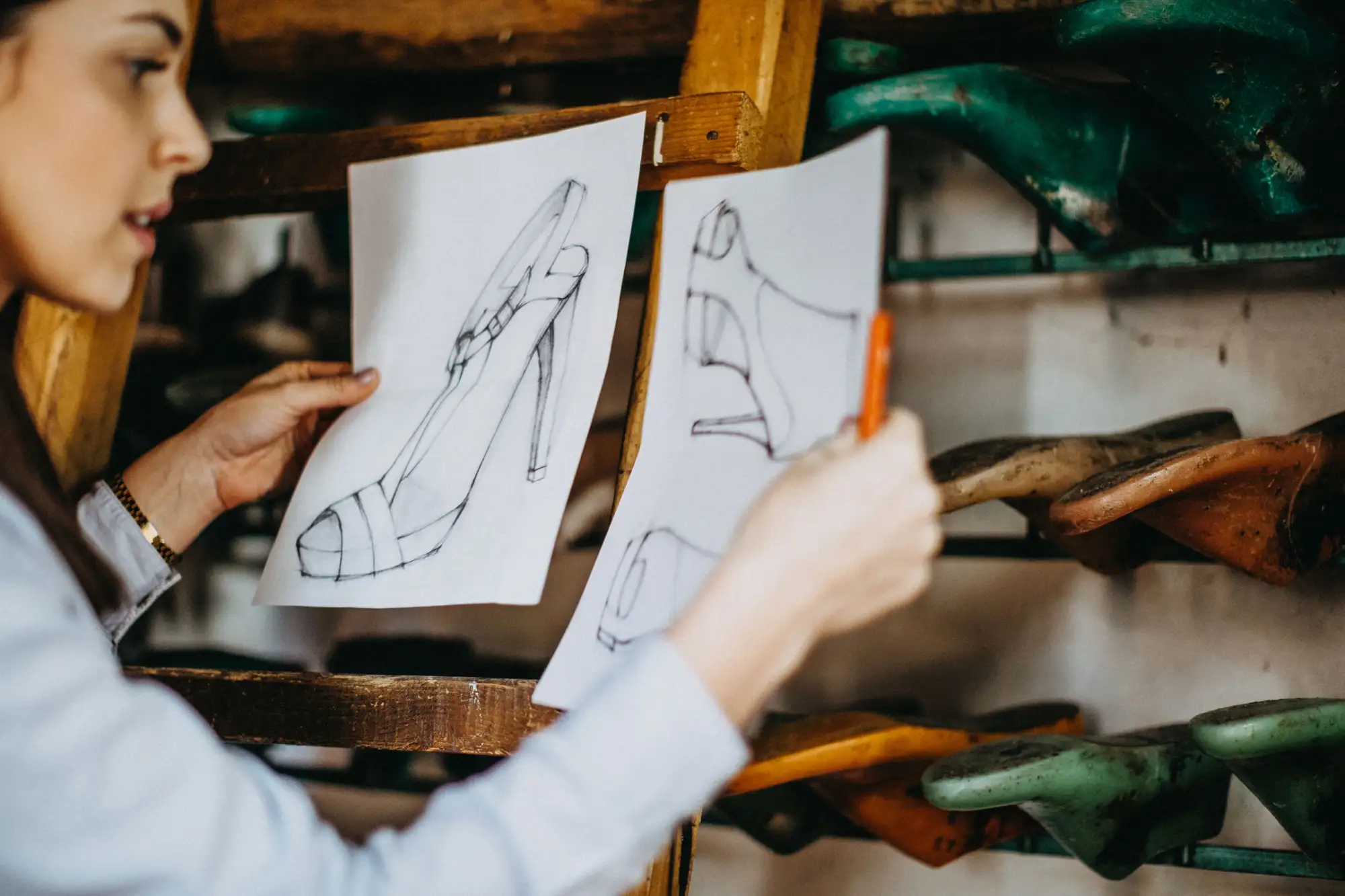 Femme regardant un dessin de chaussure en atelier