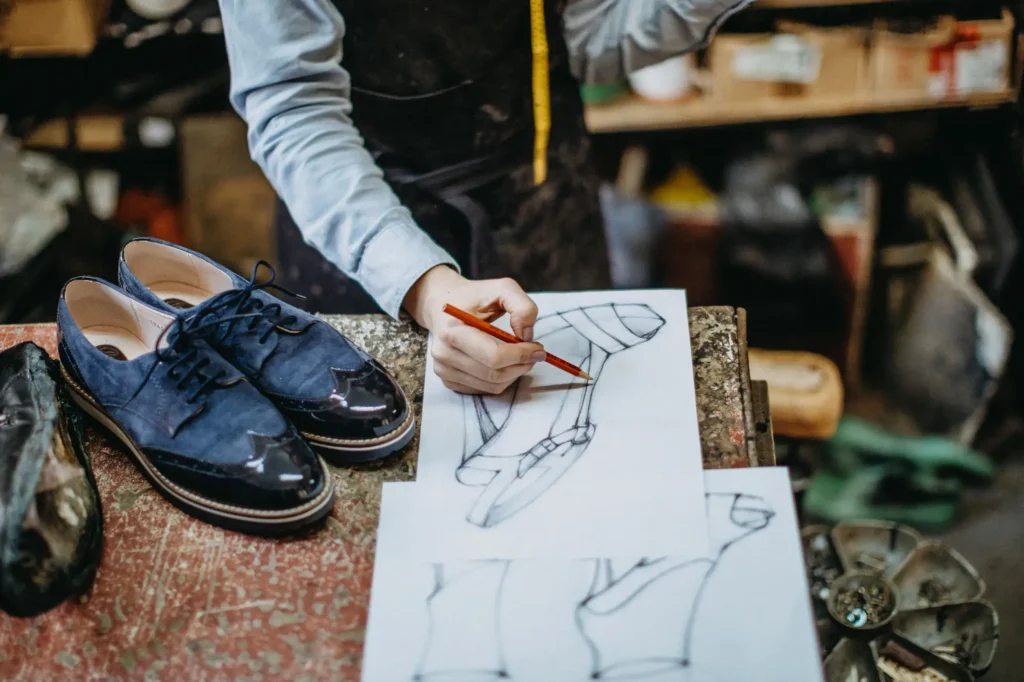 Homme dessinant une chaussure dans un atelier